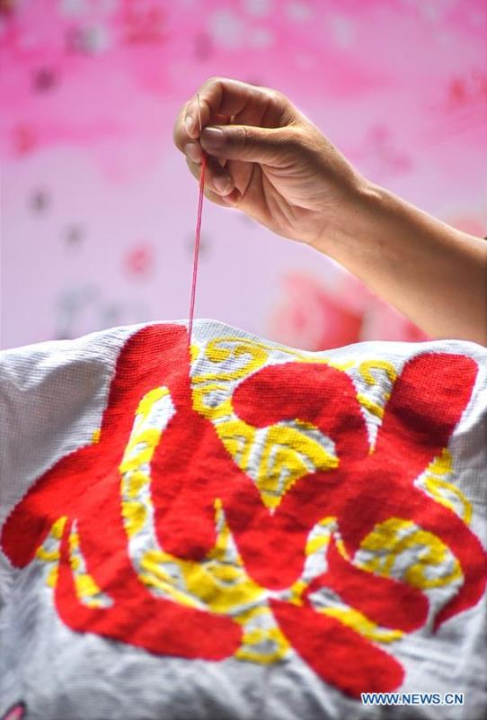 A woman makes a piece of embroidery in Yiyuan County of Zibo City, east China\'s Shandong Province, Aug. 14, 2018. In recent years, Yiyuan government has made efforts on the development of knitting and embroidery industry. Through establishing cooperatives and industry associations, the government helps to open up domestic and international market for products and raise income for the locals. (Xinhua/Zhao Dongshan)