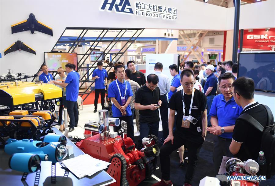 People visit the HIT Robot Group booth at World Robot Conference 2018 in Beijing, capital of China, Aug. 15, 2018. Kicking off on Wednesday, the Conference attracted contestants from 16 countries and regions to participate in the contest section. (Xinhua/Zhang Chenlin)