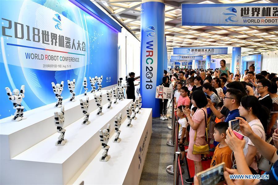 Visitors watch robots dancing performance at World Robot Conference 2018 in Beijing, capital of China, Aug. 15, 2018. Kicking off on Wednesday, the conference attracted more than 160 domestic and international corporations exhibiting their cutting-edge products in the robotics industry. (Xinhua/Li Xin)