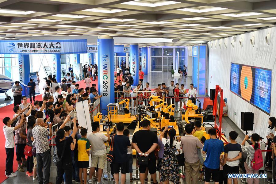 Visitors watch the performance of a robot band at World Robot Conference 2018 in Beijing, capital of China, Aug. 15, 2018. Kicking off on Wednesday, the conference attracted more than 160 domestic and international corporations exhibiting their cutting-edge products in the robotics industry. (Xinhua/Li Xin)