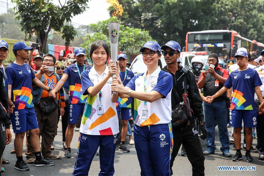 hinese torch bearer Zhang Hongyi (L Front) participates in the Torch Relay in Jakarta, Indonesia, Aug. 15, 2018. The 2018 Asian Games will kick off here on Aug. 18. (Xinhua/Zhu Wei)