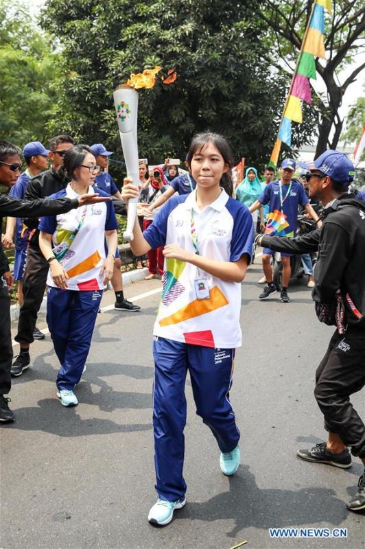 Chinese torch bearer Zhang Hongyi (C) participates in the Torch Relay in Jakarta, Indonesia, Aug. 15, 2018. The 2018 Asian Games will kick off here on Aug. 18. (Xinhua/Zhu Wei)