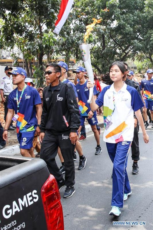 Chinese torch bearer Zhang Hongyi (C) participates in the Torch Relay in Jakarta, Indonesia, Aug. 15, 2018. The 2018 Asian Games will kick off here on Aug. 18. (Xinhua/Zhu Wei)