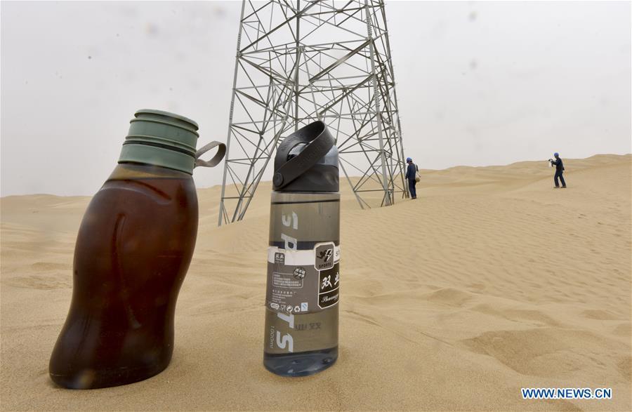 Photo taken on June 13, 2018 shows two bottles of water for linemen as they patrol along the Luntai-Tazhong-Qiemo-Ruoqiang power transmission and transformation line across the Taklimakan Desert in northwest China\'s Xinjiang Uygur Autonomous Region. The 563-kilometer power line across the Taklimakan Desert is the world\'s longest 220KV power transmission and transformation line. It was put into operation at the end of 2011, providing reliable power supply for local residents. The Taklimakan Desert, China\'s largest, is called \