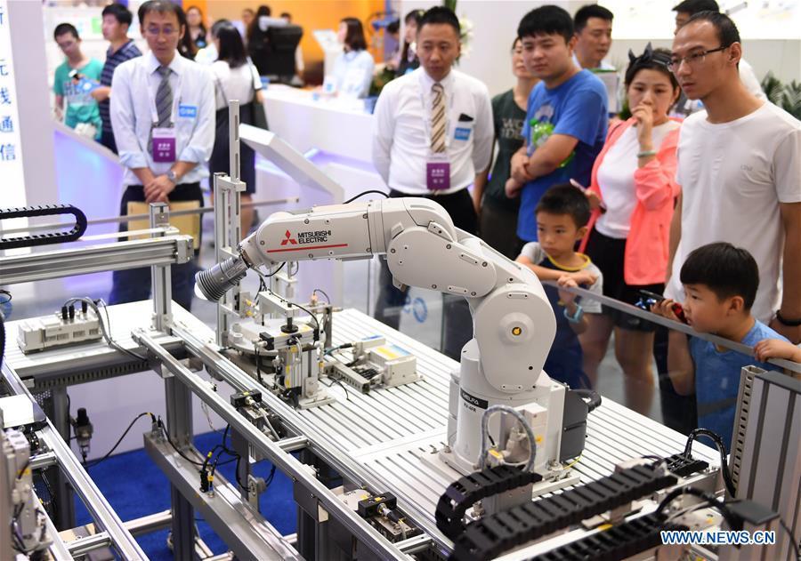 Visitors view an industrial robot at World Robot Conference 2018 in Beijing, capital of China, Aug. 15, 2018. Kicking off on Wednesday, the Conference attracted contestants from 16 countries and regions to participate in the contest section. (Xinhua/Zha