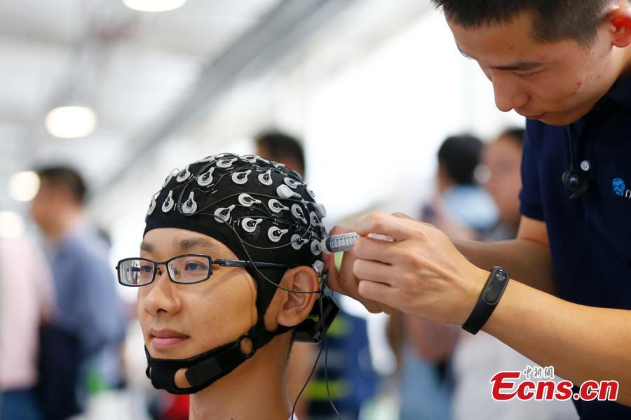 A visitor experiences a robot system at the World Robot Conference 2018 in Beijing, Aug. 15, 2018. The conference included a competitive section, which attracted contestants from 16 countries and regions. (Photo: China News Service/Fu Tian)