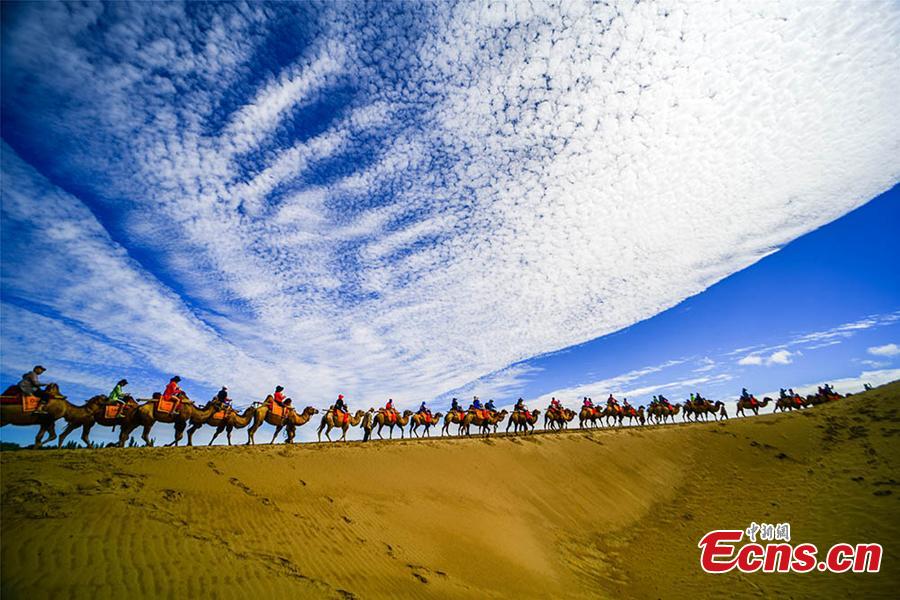 Tourists visit the Mingsha Hill scenic spot in the Gobi desert in Dunhuang City, Northwest China\'s Gansu Province, Aug. 15, 2018. Consisting of a group of sand dunes, the Mingsha Hill, or \