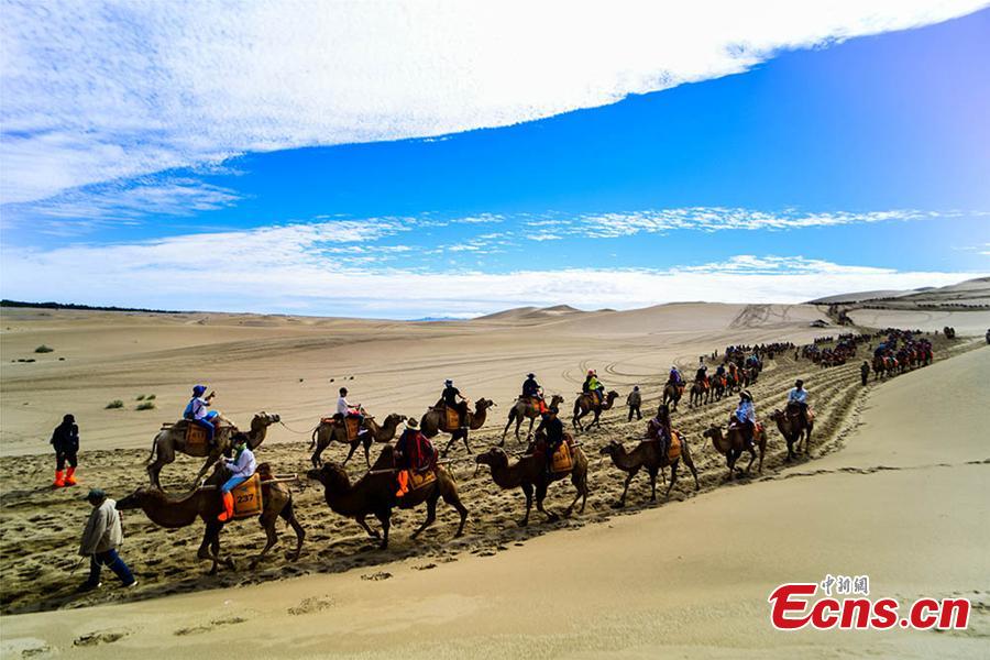 Tourists visit the Mingsha Hill scenic spot in the Gobi desert in Dunhuang City, Northwest China\'s Gansu Province, Aug. 15, 2018. Consisting of a group of sand dunes, the Mingsha Hill, or \
