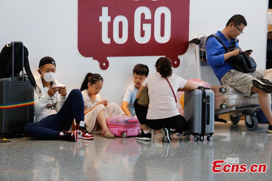 Passengers wait at the departure hall of Pudong International Airport in Shanghai, Aug. 17, 2018. Some flights in Hongqiao International Airport and Putong International Airport in Shanghai were delayed or cancelled due to the Typhoon Rumbia. （Photo: China News Service/Yin Liqin）