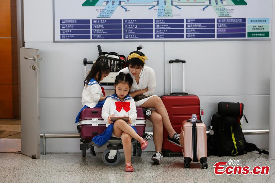 Passengers wait at the departure hall of Pudong International Airport in Shanghai, Aug. 17, 2018. Some flights in Hongqiao International Airport and Putong International Airport in Shanghai were delayed or cancelled due to the Typhoon Rumbia. （Photo: China News Service/Yin Liqin）