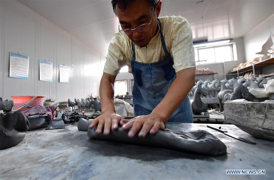 Tri-colored glazed pottery technique inheritor Gao Shuiwang makes clay for potteries in Nanshishan Village, Mengjin County, Luoyang City, central China\'s Henan Province, Aug. 15, 2018. Gao is a leading figure in the revival of tri-colored glazed pottery, or Sancai, a Chinese porcelain characterized by a glaze with three intermingled colours. The producing technique of Sancai, which flourished in the Tang Dynasty (618-907 AD), was very complex and listed as one of China\'s National Intangible Heritages in 2008. Nanshishan Village in Henan is regarded as an important village of Sancai culture, with more than 70 enterprises now engaging in the industry. (Xinhua/Feng Dapeng)