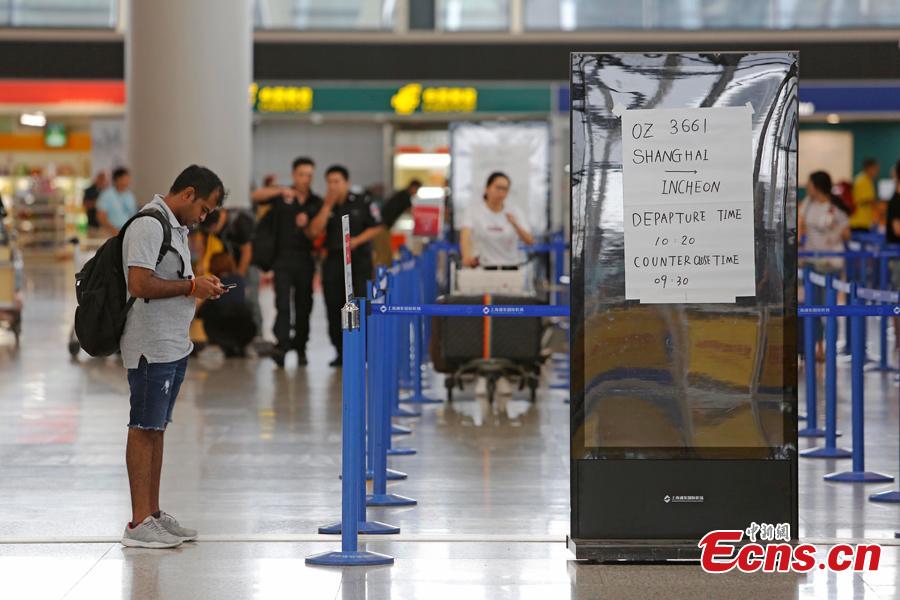 Passengers wait at the departure hall of Pudong International Airport in Shanghai, Aug. 17, 2018. Some flights in Hongqiao International Airport and Putong International Airport in Shanghai were delayed or cancelled due to the Typhoon Rumbia. （Photo: China News Service/Yin Liqin）
