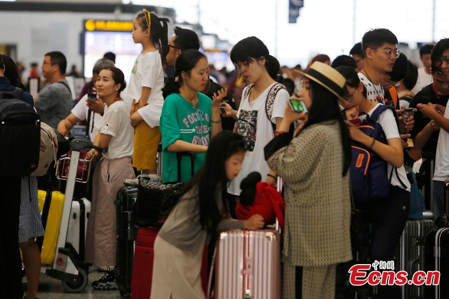 Passengers wait at the departure hall of Pudong International Airport in Shanghai, Aug. 17, 2018. Some flights in Hongqiao International Airport and Putong International Airport in Shanghai were delayed or cancelled due to the Typhoon Rumbia. （Photo: China News Service/Yin Liqin）