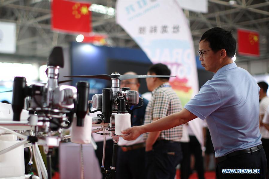 A visitor views a drone displayed during the 7th Faku Flight Conference in Shenyang, capital of northeast China\'s Liaoning Province, Aug. 18, 2018. The flight conference kicked off here on Saturday. (Xinhua/Yao Jianfeng)