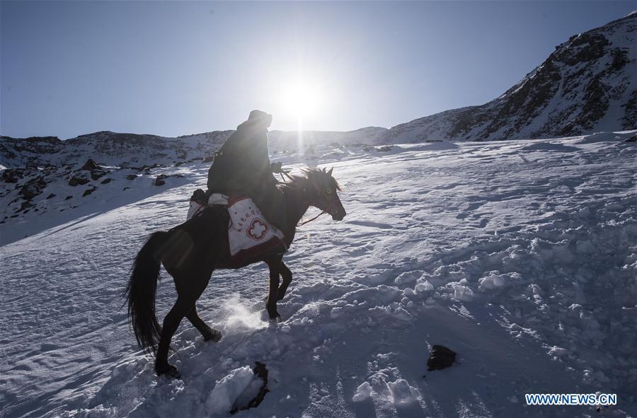 Doctor Yelixat and his horse pass through snow-covered slope during a medical service trip around a pastoral area in Tekes County of Ili Kazakh Autonomous Prefecture, northwest China\'s Xinjiang Uygur Autonomous Region, Dec. 15, 2017. A large number of medical practitioners are active in China\'s rural areas where health care is still underdeveloped. Under adverse working conditions, they have carried forward the humanitarian spirit and devoted themselves to the health of rural citizens. China will mark its first Medical Workers\' Day on Aug. 19, 2018. (Xinhua/Jiang Wenyao)