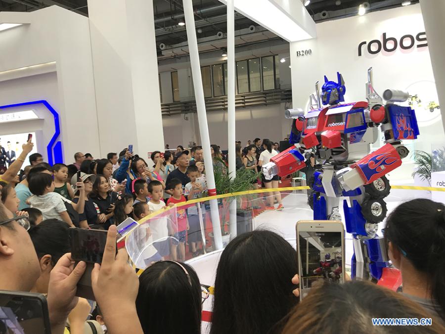 Visitors watch a robot performing at the 2018 World Robot Conference in Beijing, Aug. 17, 2018. The conference attracts a total of 166 domestic and international enterprises exhibiting their cutting edge technologies and more than 500 items are displayed at the scene. (Xinhuanet/Liang Yurou)