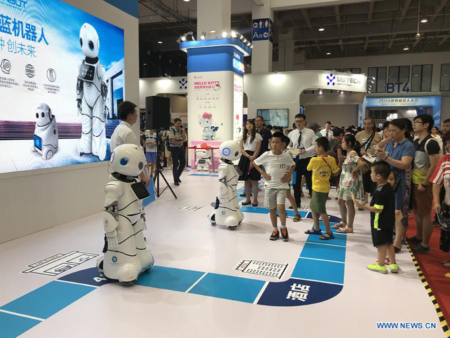 Visitors watch robots performing at the 2018 World Robot Conference in Beijing, Aug. 17, 2018. The conference attracts a total of 166 domestic and international enterprises exhibiting their cutting edge technologies and more than 500 items are displayed at the scene. (Xinhuanet/Liang Yurou)