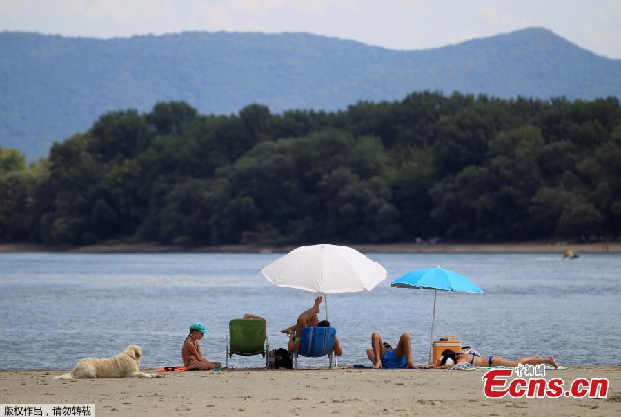 People enjoy warm weather on a gravel shoal in the middle of the Danube river during the period of low water level near Esztergom, Hungary, August 19, 2018. (Photo/Agencies)