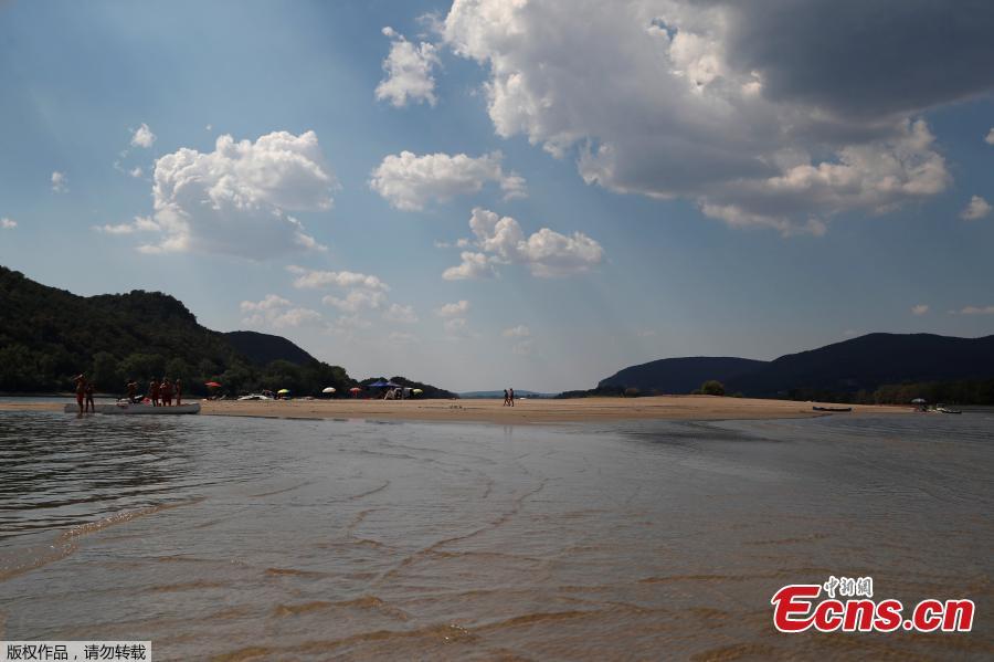 People walk on a gravel shoal in the middle of the Danube river during the period of low water level near Esztergom, Hungary, August 19, 2018. (Photo/Agencies)