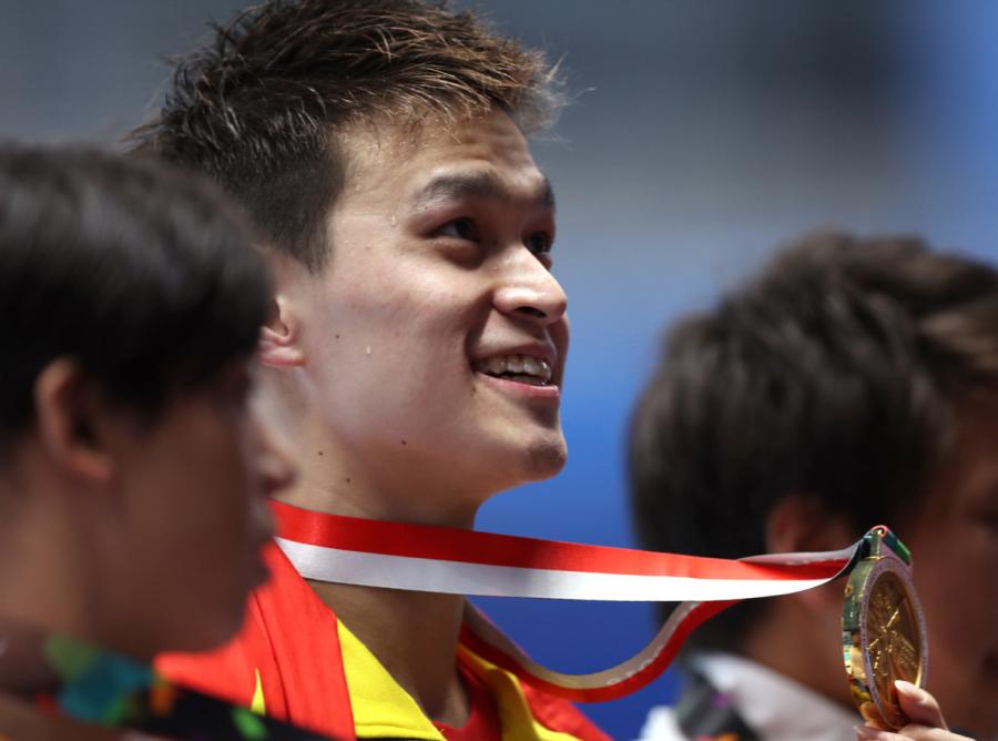 China\'s Sun Yang shows his gold medal after winning the gold medal at men\'s 200m freestyle final at the GBK Aquatics Center in Jakarta, Indonesia on Aug. 19, 2018. (Photo/Xinhua)