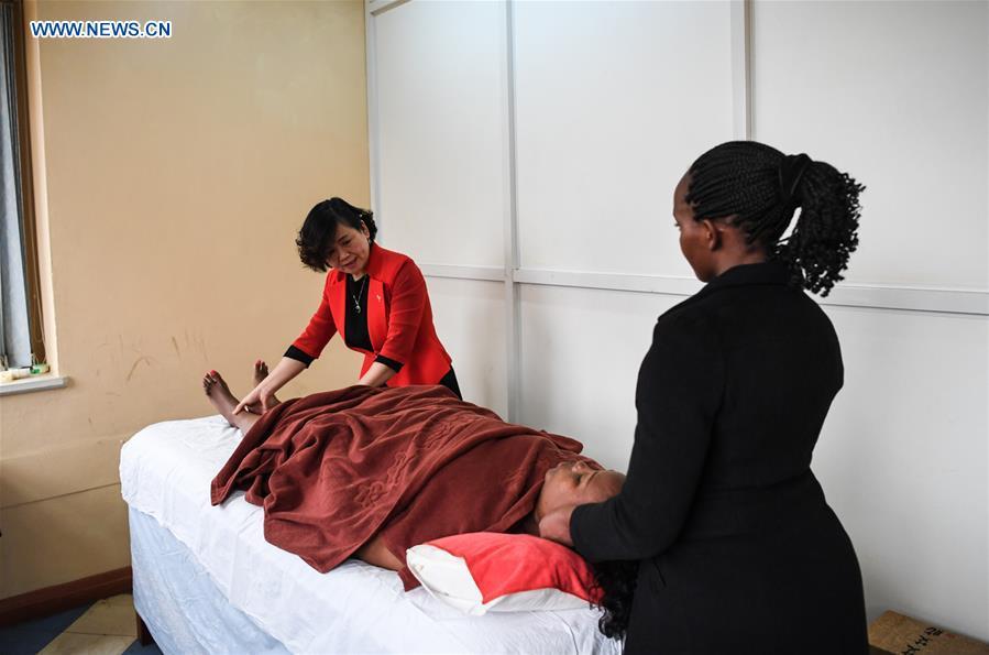 Pan Lianxue shows the skills of tui na (Chinese therapeutic massage) to her local employee at her clinic in Nairobi, Kenya, Aug. 17, 2018. Pan Lianxue and her husband Luo Zhanliang, both Chinese doctors in traditional Chinese medicine, have been operated a clinic in Nairobi for over 20 years attracting more and more African patients. China issued the first Medical Workers\' Day on Aug. 19.(Xinhua/Li Yan)