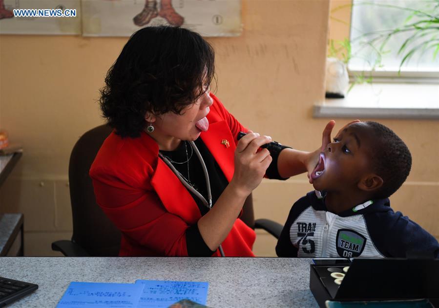 Pan Lianxue examines a local child at her clinic in Nairobi, Kenya, Aug. 17, 2018. Pan Lianxue and her husband Luo Zhanliang, both Chinese doctors in traditional Chinese medicine, have been operated a clinic in Nairobi for over 20 years attracting more and more African patients. China issued the first Medical Workers\' Day on Aug. 19.(Xinhua/Li Yan)