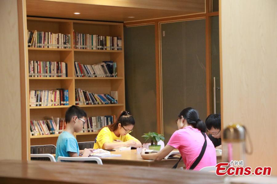 People read books at the newly-opened West Lake Bookstore in Hangzhou City, East China’s Zhejiang Province, Aug. 20, 2018. Hangzhou residents can access the unmanned bookstore, and borrow or return books all by swiping their IDs. Non-Hangzhou residents still need a conventional library card. (Photo: China News Service/Liu Peiqi)