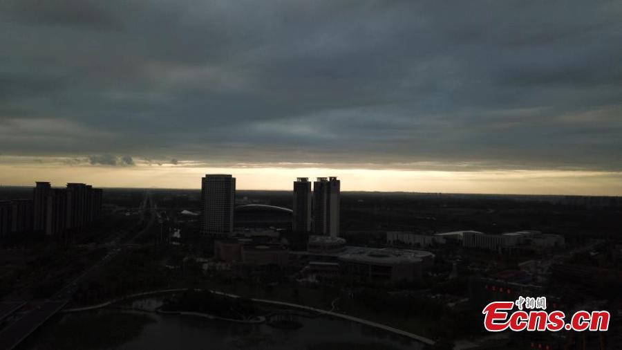 Dark clouds create a distinct line in the sky as the sun sets over Yangzhou City, Jiangsu Province, Aug. 21, 2018. The sunset created an intense orange glow that contrasted with the dark clouds, creating a spectacular natural wonder. (Photo: China News Service/Meng Delong)
