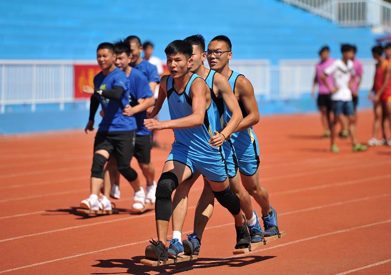 Competitors are race walking with team members’ feet fastened to a board at the 10th Provincial Traditional Ethnic Sports Games in Hebei Province, Aug. 21, 2018. (Photo by Yuan Liwei for chinadaily.com.cn)
