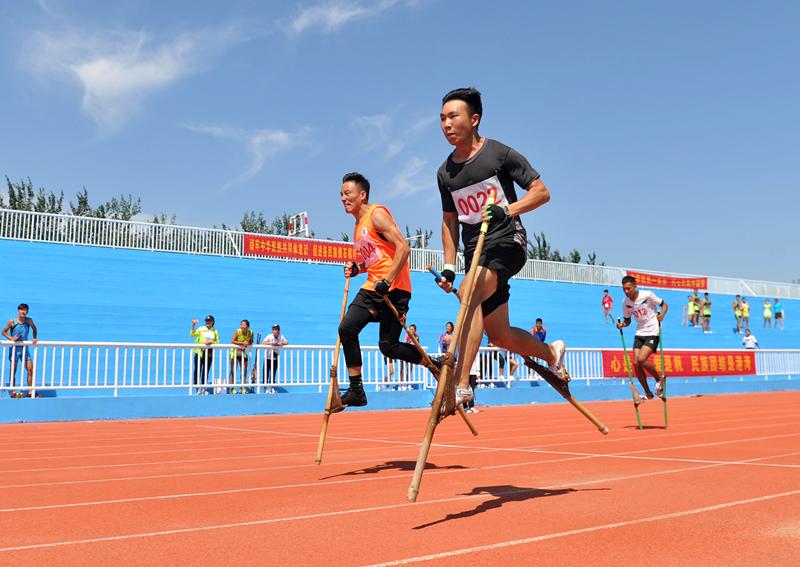Competitors are race walking on stilts at the 10th Provincial Traditional Ethnic Sports Games in Hebei Province, Aug. 21, 2018. (Photo by Yuan Liwei for chinadaily.com.cn)