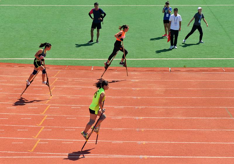 Competitors are race walking on stilts at the 10th Provincial Traditional Ethnic Sports Games in Hebei Province, Aug. 21, 2018. (Photo by Yuan Liwei for chinadaily.com.cn)