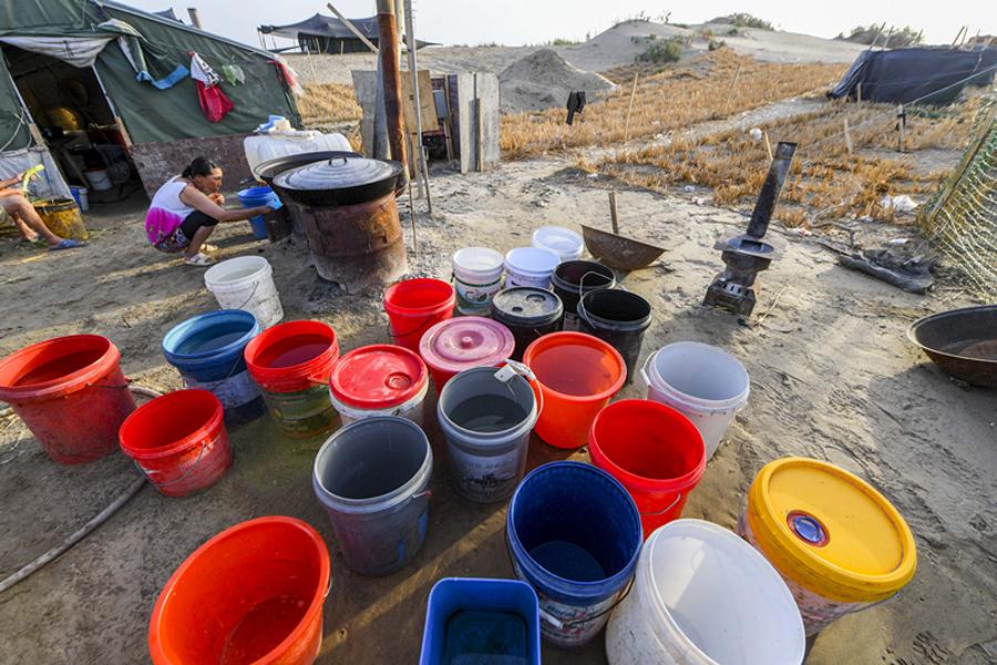 Buckets, for water storage, are a daily essential for living in the desert. (Photo/Xinhua)
There are a lot of couples in this team, which explains the good teamwork. The men carry up to 70 kilograms of reeds onto the dunes, the women lay the reeds on the sand, and then the men drive the dried reeds into the sand.
Every step in the desert is twice as hard than on stable ground. Some of the women work only in socks.
After work, there is little entertainment. Every day, Yang\'s wife calls her family.
Zhang said they used to keep chickens in the hope of improving their meal options, but strong winds swept two of the birds away. \