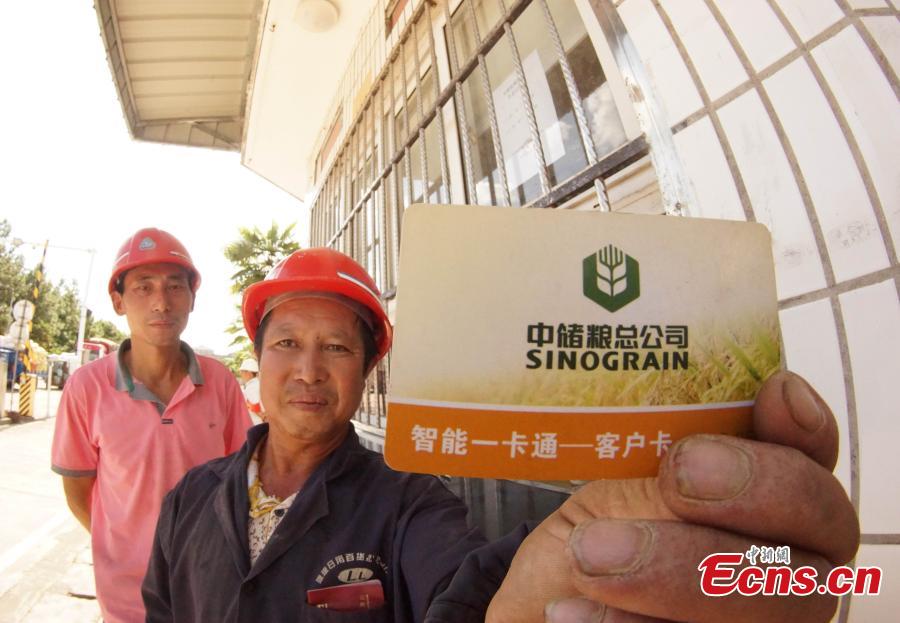 Photo taken on Aug. 23, 2018 shows farmers selling their newly harvested rice at the Sinograin Wannian Depot in Wannnian County, East China’s Jiangxi Province. (Photo: China News Service/Wang Haoyang)
