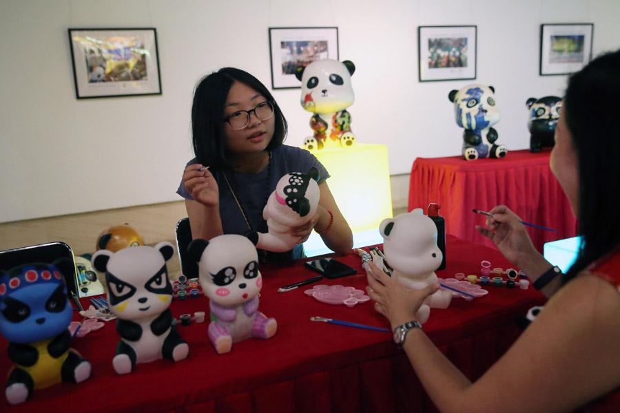 Artists work on panda products at the China Giant Panda International Culture Week in Beijing on Thursday. (Photo/CHINA DAILY)

So far, 58 giant pandas have been involved in international cooperative research projects, and 47 giant panda cubs have been bred abroad, of which 31 have returned to China as required, said Yang Chao, director of the administration\'s wildlife protection department.