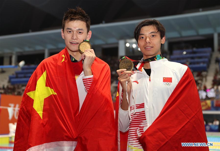 Gold medalist Sun Yang (L) of China and bronze medalist Ji Xinjie of China pose for pictures after the awarding ceremony of men\'s 1500m freestyle final of swimming at the 18th Asian Games in Jakarta, Indonesia, Aug. 24, 2018. (Xinhua/Fei Maohua)