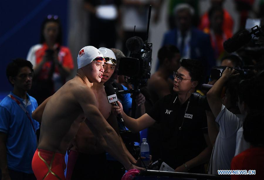 Sun Yang (L front) of China gets interviewed after men\'s 1500m freestyle final of swimming at the 18th Asian Games in Jakarta, Indonesia, Aug. 24, 2018. Sun won the gold medal. (Xinhua/Yue Yuewei)