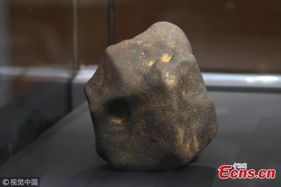 Photo taken on Aug. 25, 2018 shows a meteorite exhibited at a press conference held by Shanghai Planetarium in east China\'s Shanghai. Shanghai Planetarium on Saturday announced plans to house meteorites recovered from a meteor fireball that happened over the sky in Jinghong City of southwest China\'s Yunnan Province in June. The planetarium, which is under construction, will be a branch of the Shanghai Science & Technology Museum. The museum staff have successfully recovered more than 500 pieces of meteorites, about 50 kg in total, said Lin Qing, deputy director in charge of the planetarium construction, at a press conference Saturday. (Photo/VCG)