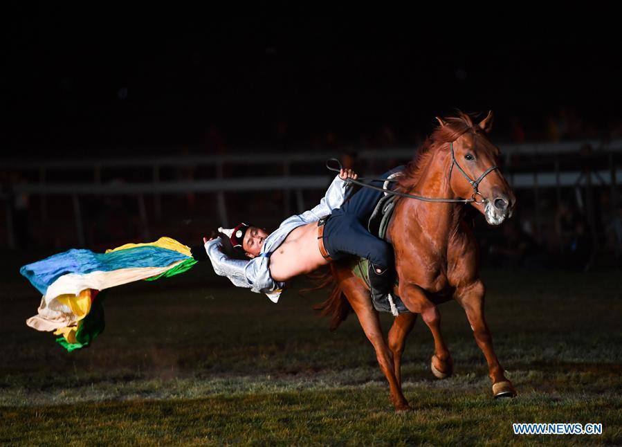 A performer collects hada (a piece of silk used as a greeting gift) on horse during the opening ceremony of a horse-themed art week in Hohhot, capital of north China\'s Inner Mongolia Autonomous Region, Aug. 27, 2018. Kicked off here on Monday, the art week will include art performances, beer and food festival, and equestrian performances. (Xinhua/Peng Yuan)
