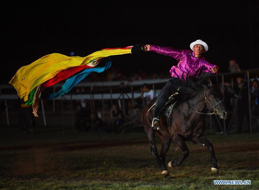 A performer collects hada (a piece of silk used as a greeting gift) on horse during the opening ceremony of a horse-themed art week in Hohhot, capital of north China\'s Inner Mongolia Autonomous Region, Aug. 27, 2018. Kicked off here on Monday, the art week will include art performances, beer and food festival, and equestrian performances. (Xinhua/Peng Yuan)
