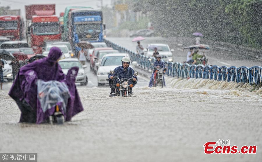 Motorcyclists drive on a flooded road after a rainstorm in Quanzhou City, East China’s Fujian Province, Aug. 29, 2018. (Photo/VCG)