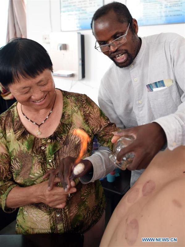 Diarra teaches a local doctor way of cupping at a health center in Kaiyuan City of Hani-Yi Autonomous Prefecture of Honghe, southwest China\'s Yunnan Province, June 6, 2017. (Xinhua/Wang Changshan)