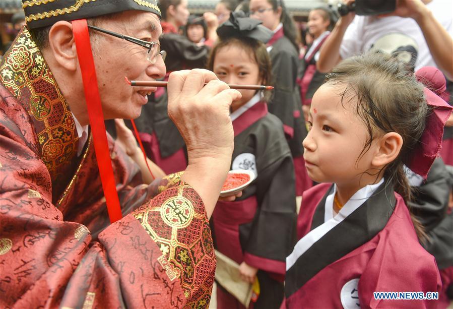 People engage in an activity to pay respects to their teachers in Fuzhou, capital of southeast China\'s Fujian Province, Sept. 1, 2018. The activity is held to greet the new semester on the school opening day which falls on Sept. 1. (Xinhua/Song Weiwei)