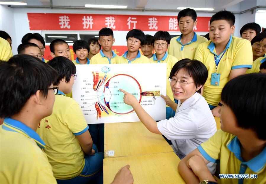 Medical staff illustrates eye care tips at a middle school in Hengshui, north China\'s Hebei Province, Sept. 1, 2018. To cultivate a good habit of using eyes, schools in China prepare eye-care activities for students on the school opening day which falls on Sept. 1. (Xinhua/Zhu Xudong)