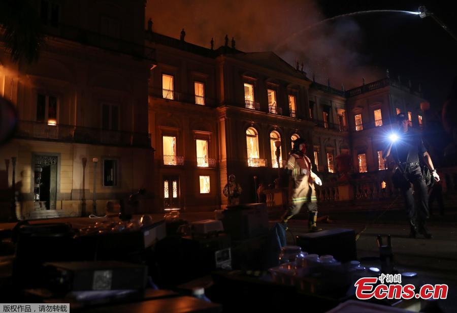 A police officer shines a light at rescued items during a fire at the National Museum of Brazil in Rio de Janeiro, Brazil September 2, 2018. (Photo/Agencies)