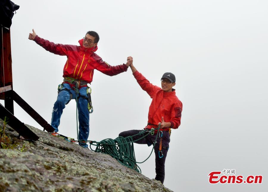 Li Tongxing and Gong Xiuming celebrate after reaching the top in a rock-climbing contest, part of a sports festival in Oroqen Autonomous Banner, North China’s Inner Mongolia Autonomous Region, Sept. 3, 2018. (Photo: China News Service/Hou Yupeng)