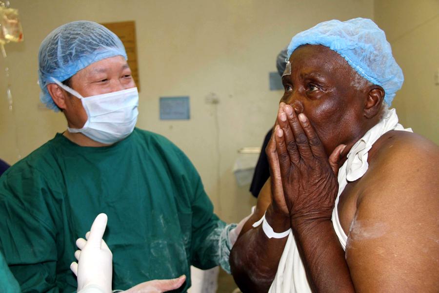 A patient is overwhelmed as his sight is restored after an operation in 2010 at a hospital in Harare, Zimbabwe. Chinese medical teams were sent to Zimbabwe to tackle eye disease. (Photo/Xinhua)