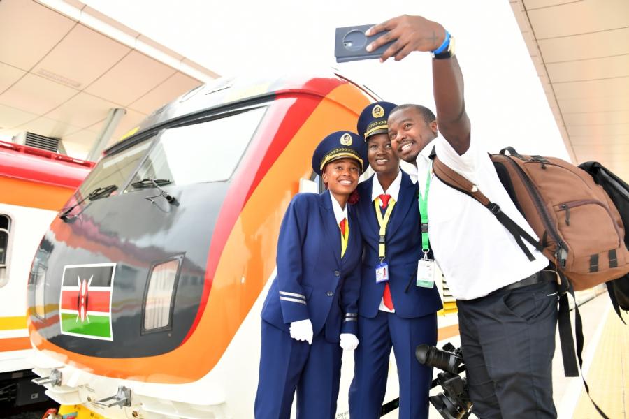 Train staff and a journalist pose for a selfie in Mombasa, Kenya, last year in front of the Madaraka Express train. (Photo/Xinhua)