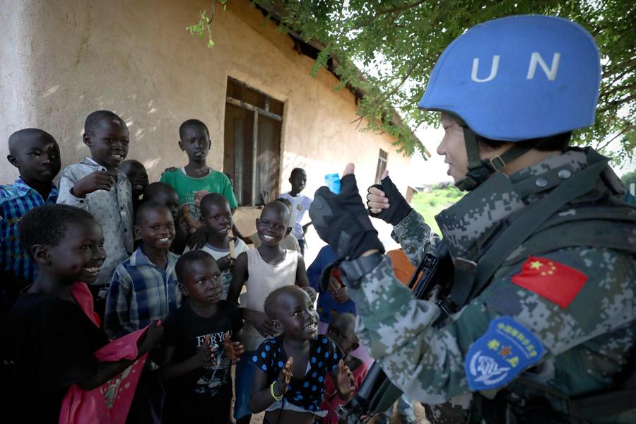 Chinese UN peacekeeper Yu Peijie, 26, sings songs with children in Juba, South Sudan, in April. Yu is the leader of an all-female Chinese peacekeeping battalion in the African country. This year marks the 70th anniversary of United Nations peacekeeping operations and the 28th anniversary of China\'s participation in them. Around 2,500 Chinese peacekeepers are part of UN missions and are involved in activities ranging from minesweeping and road repairs to guarding sensitive installations and providing free clinics. China\'s comprehensive participation in UN peacekeeping operations over the years has earned it deep respect from the rest of the world. (Photo/Xinhua)