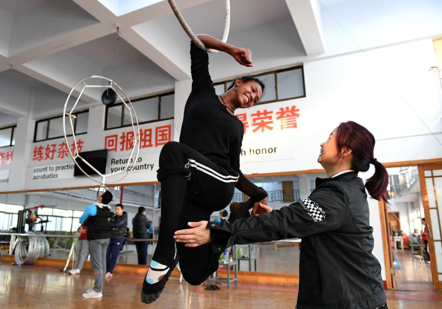 An Ethiopian student has a helping hand from a teacher at Wuqiao Acrobatic Art School in Hebei Province in 2016. (Photo/Xinhua)