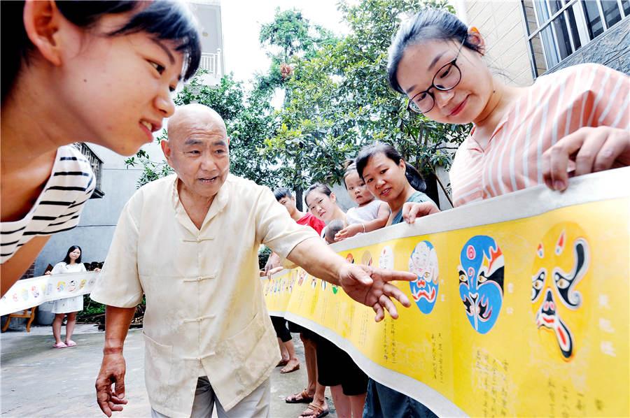 Zhao Xichun introduces his Peking Opera mask scroll in his workshop in Shaorao city, Jiangxi Province on Sept. 2, 2018. (Photo/Asianewsphoto)